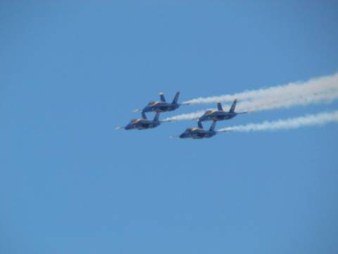 Four Blue Angel jets flying in a diamond formation